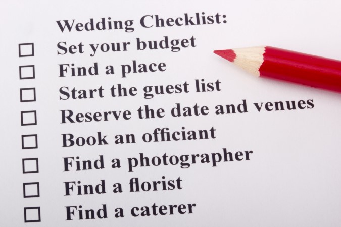 Red pencil laying on a wedding checklist.