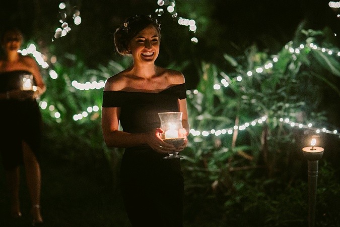 Bridesmaid walking down the aisle with candle. 