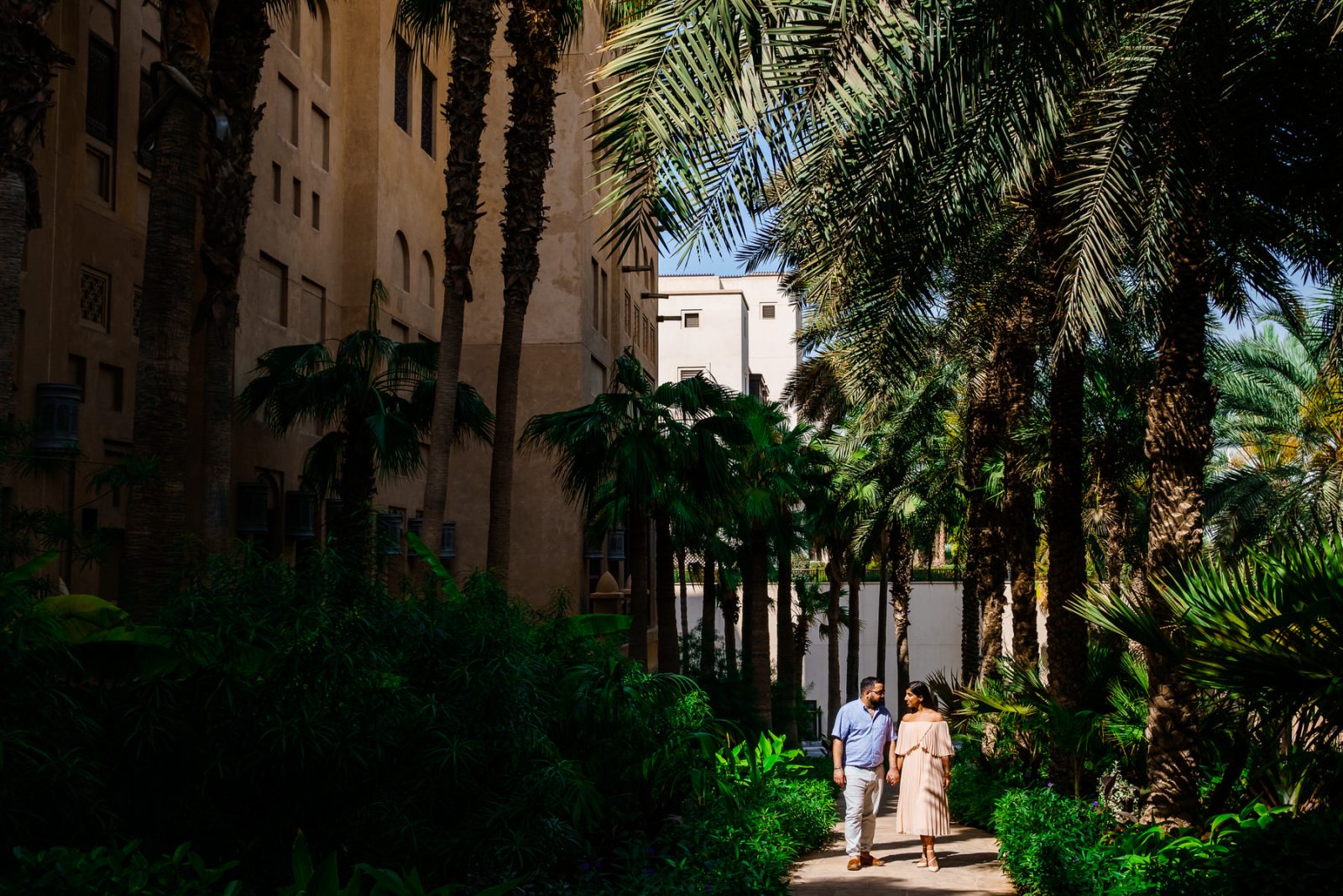 Couple walking hand in hand with palm trees in Dubai