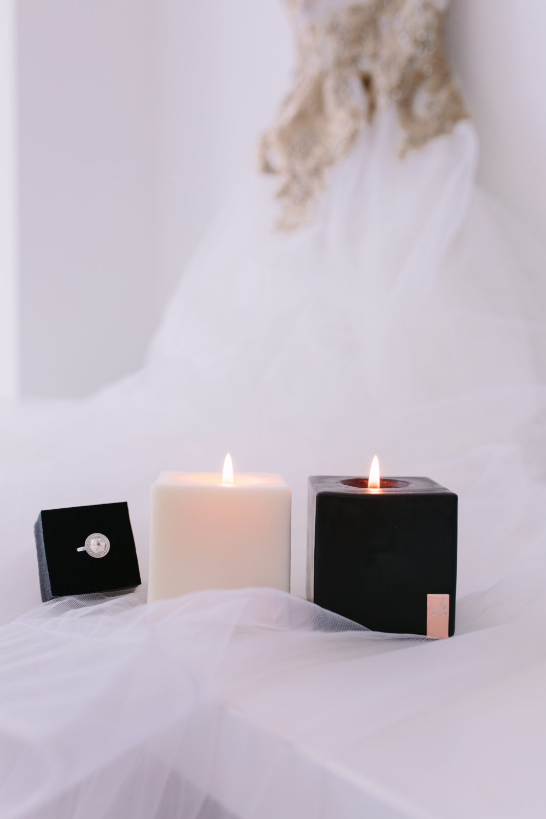 Lava Candles next to wedding dress and engagement ring