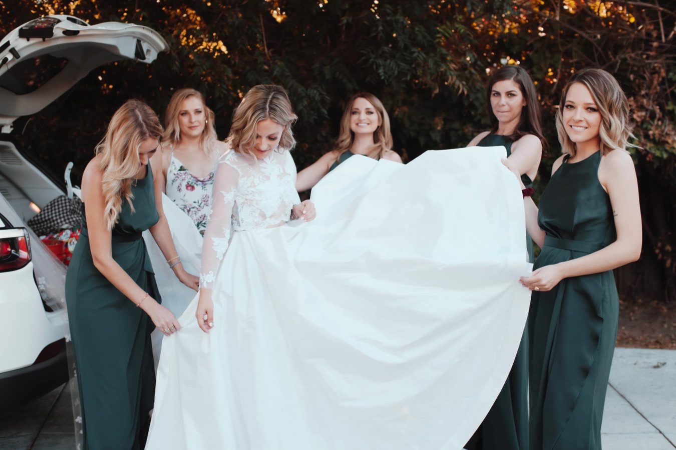 Bridesmaids helping Bride with dress 