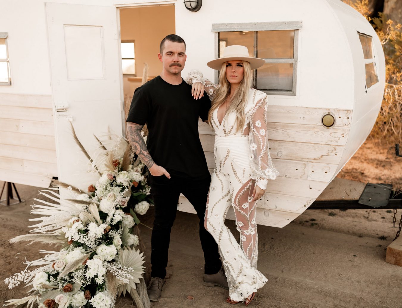 A wedding couple in front of a camper